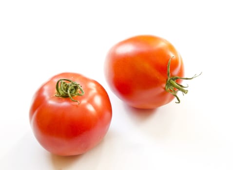 A couple of tomatoes on a white illuminated background. Healthy ecological food.