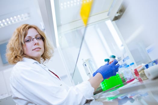 portrait of a female researcher doing research in a lab (shallow DOF; color toned image)