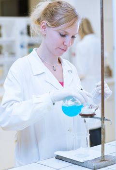 portrait of a female researcher carrying out research in a chemistry lab (color toned image; shallow DOF)