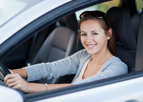 Pretty young woman driving her new car