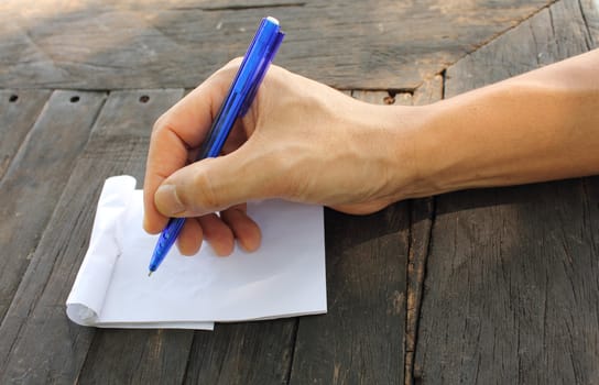 Asian male hand holding pen on an empty paper