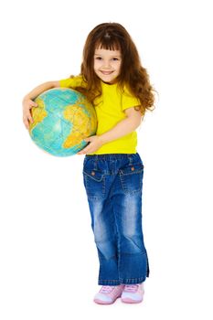Cheerful little girl in jeans with a geographic globe isolated on white background