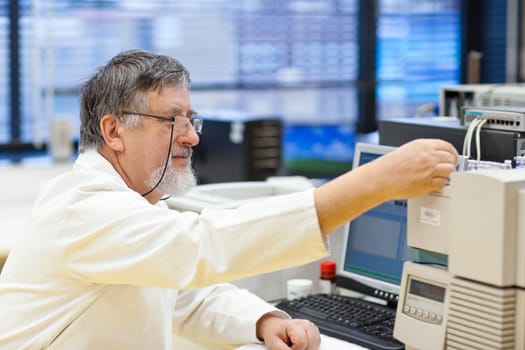 senior male researcher carrying out scientific research in a lab (shallow DOF; color toned image)