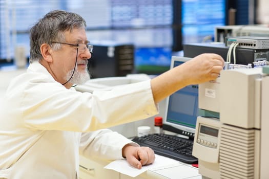 senior male researcher carrying out scientific research in a lab (shallow DOF; color toned image)