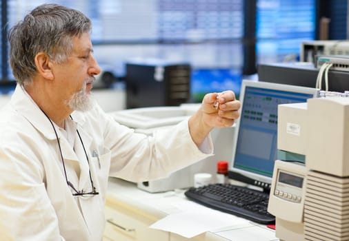 senior male researcher carrying out scientific research in a lab (shallow DOF; color toned image)