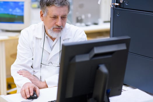 senior male researcher carrying out scientific research in a lab (shallow DOF; color toned image)