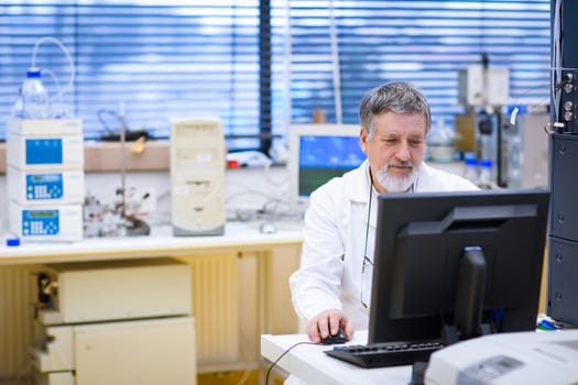 senior male researcher carrying out scientific research in a lab (shallow DOF; color toned image)