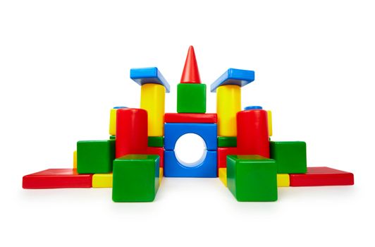 Pile of colored toy bricks like a castle on white