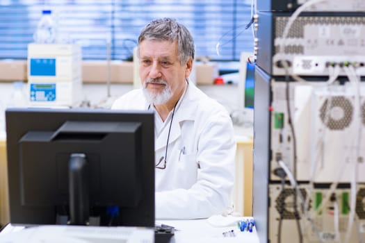 senior male researcher carrying out scientific research in a lab (shallow DOF; color toned image)