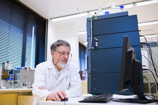 senior male researcher carrying out scientific research in a lab (shallow DOF; color toned image)