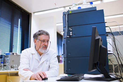 senior male researcher carrying out scientific research in a lab (shallow DOF; color toned image)