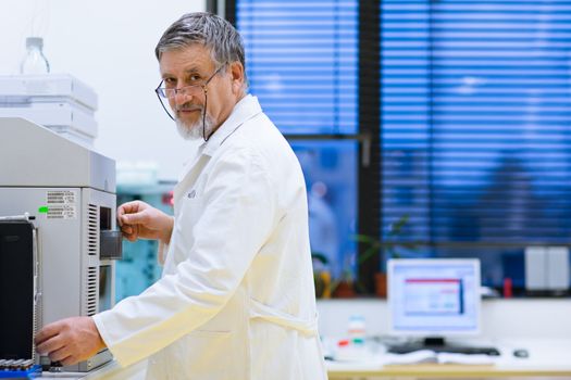 senior male researcher carrying out scientific research in a lab (shallow DOF; color toned image)