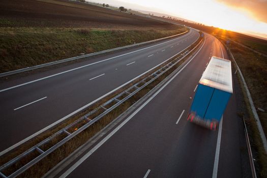 highway traffic - motion blurred truck on a highway/motorway/speedway at dusk (color toned image)