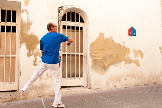 Skilled pelota player  performing a powerful serve