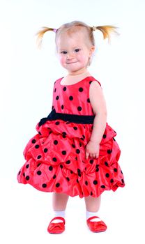 Cute little baby girl in a red dress. In the studio. Isolated