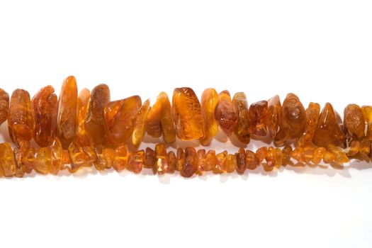 thread of amber bead on white background. close-up.