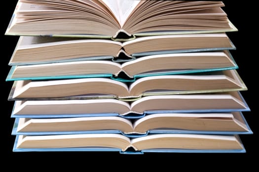 opened books, stacked on a black background
