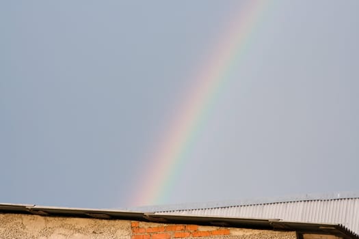 Rainbow over the rooftops on a  grey summer sky