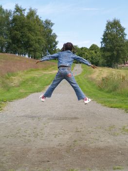 girl jumping high on park road