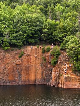 Some crazy kids cliff jumping off the side of a mountain from 60 feet up into the water below.  