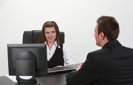 A businessman and a businesswoman at an interview in an office.