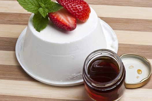 cottage cheese decorated with strawberries and mint leaves and a jar of honey