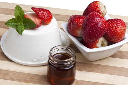 cottage cheese decorated with strawberries and mint leaves and a jar of honey
