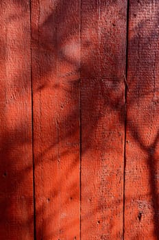 Red-painted wall boards background with shadows.