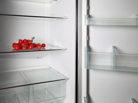 Empty refrigerator with fresh tomatos