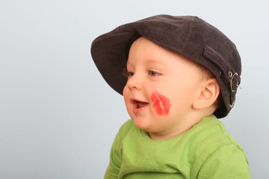 Beautiful baby boy with red lips on his cheek