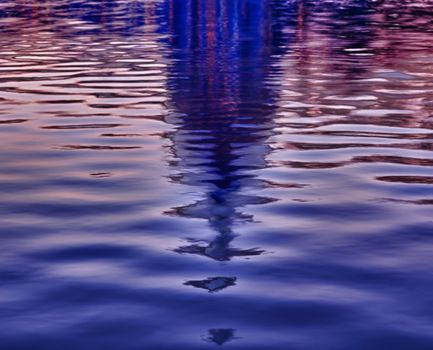 Brightly lit dawn sky behind the illuminated dome of the Capitol in Washington DC reflecting in the water of the pool in front of the building