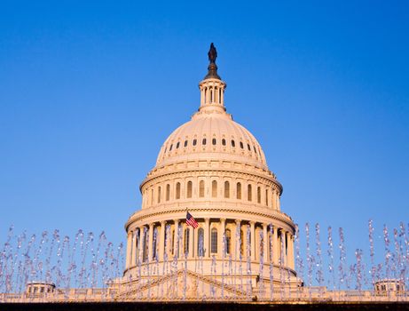 Capitol building in Washington DC illuminated early in the morning by the rising sun and giving a red/orange hue to the traditional scene