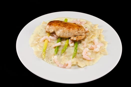Picture of a dinner plate with chicken, asparges, pasta and some shrimps