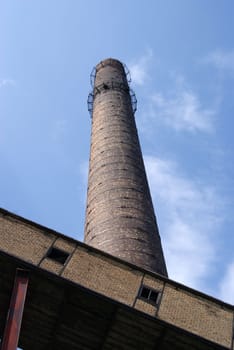 The pipe rises far in the sky, is constructed of a brick 