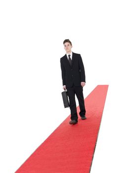 Businessman walking on a red carpet isolated on white background