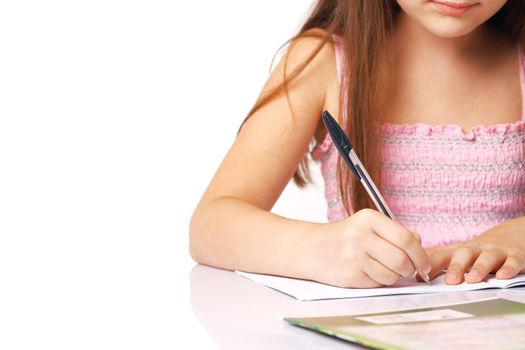 Close-up of a little girl's hand writing something in the copy-book