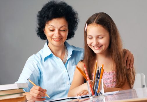 Grandmother helping her granddaughter with her home-work.