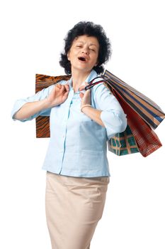 Happy elderly woman with shopping bags over white background.