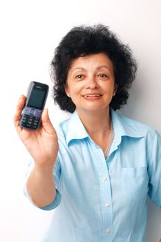 Elder smiling woman holding and showing her mobile.