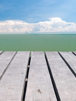 Seaside wooden bridge with beautiful cloudy and emerald color backwater sea