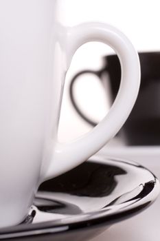 white and black cup of tea standing on the table