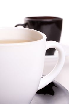 white and black cup of tea standing on the table