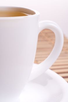 a white cup of tea standing on the table