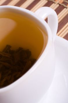 a white cup of tea standing on the table