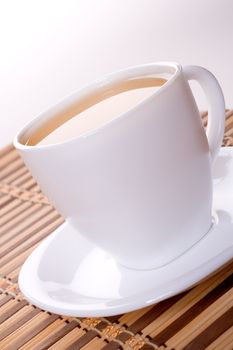 a white cup of tea standing on the table