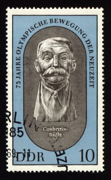 Old postage stamp from GDR with Pierre de Coubertin, founder of new Olympic Games