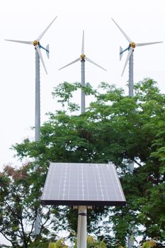 Solar energy panel and windmill in the background 