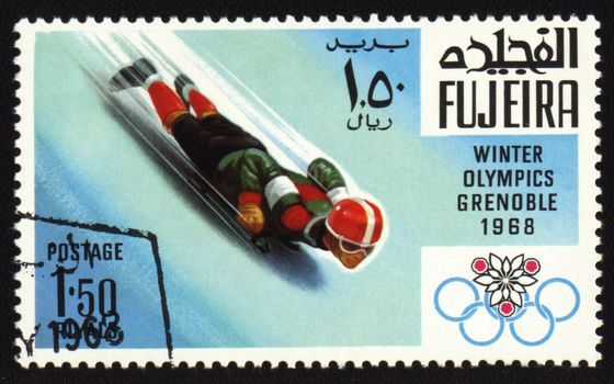 Postage stamp from Fujeira shows Winter Olympic Games in Grenoble 1968. Descent to sledge