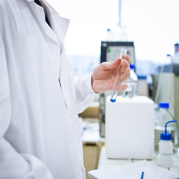 young, male researcher/chemistry student carrying out scientific research in a lab (shallow DOF; color toned image)