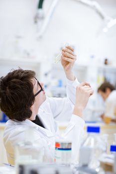 young, male researcher/chemistry student carrying out scientific research in a lab (shallow DOF; color toned image)